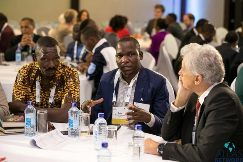 Three men in discussion at a round table at the Africa Liberty Forum.