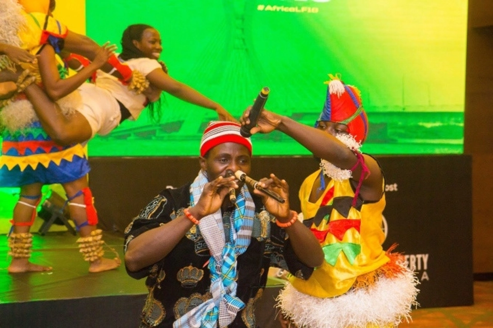 Performers dance and play music on stage.
