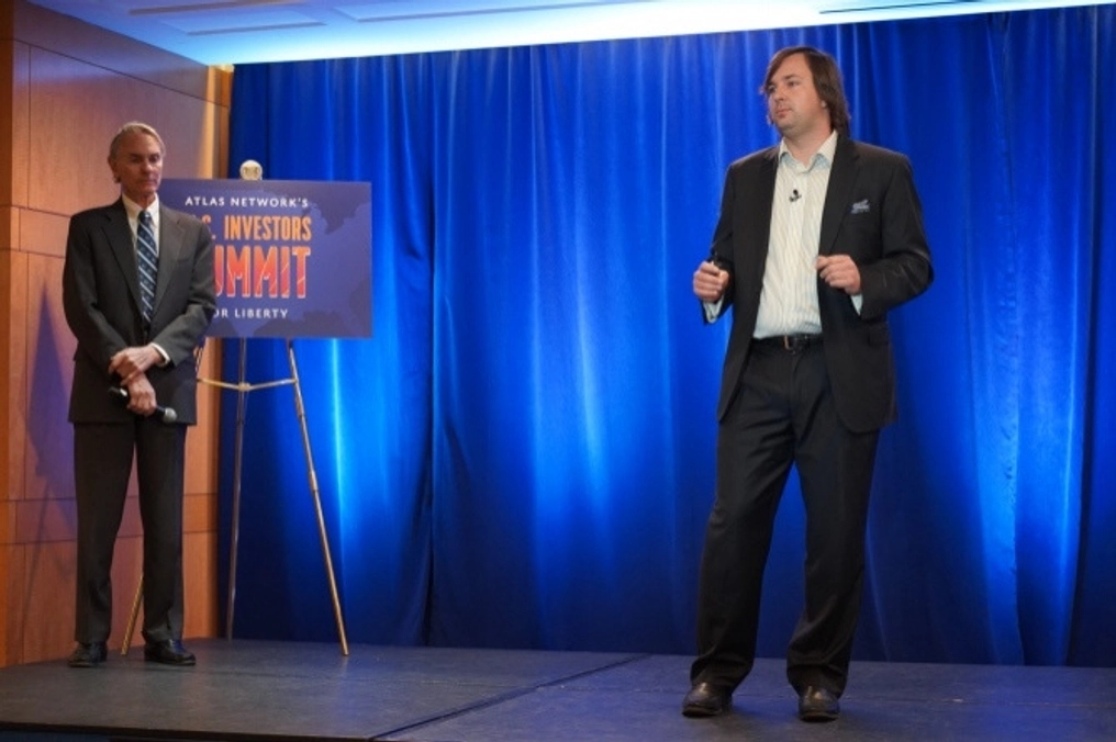 Two men on stage at the Liberty Awards Investor Summit.