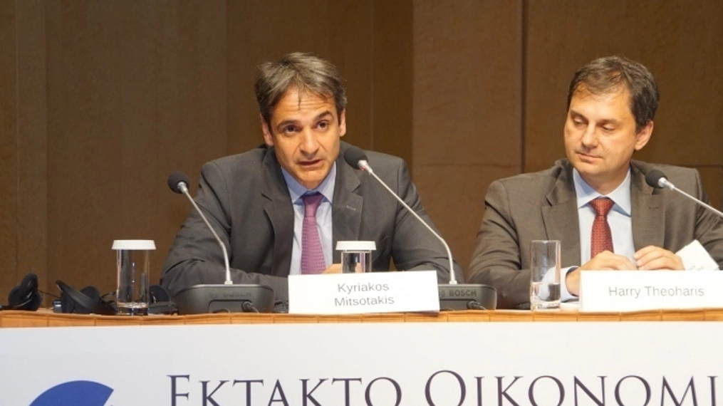 Kyriakos Mitsotakis speaks as Harry Theohans sits beside him listening.