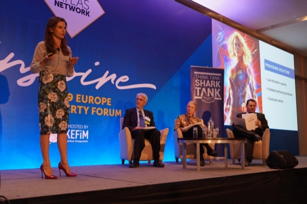 A woman delivers her pitch as judges watch at the Think Tank Shark Tank.
