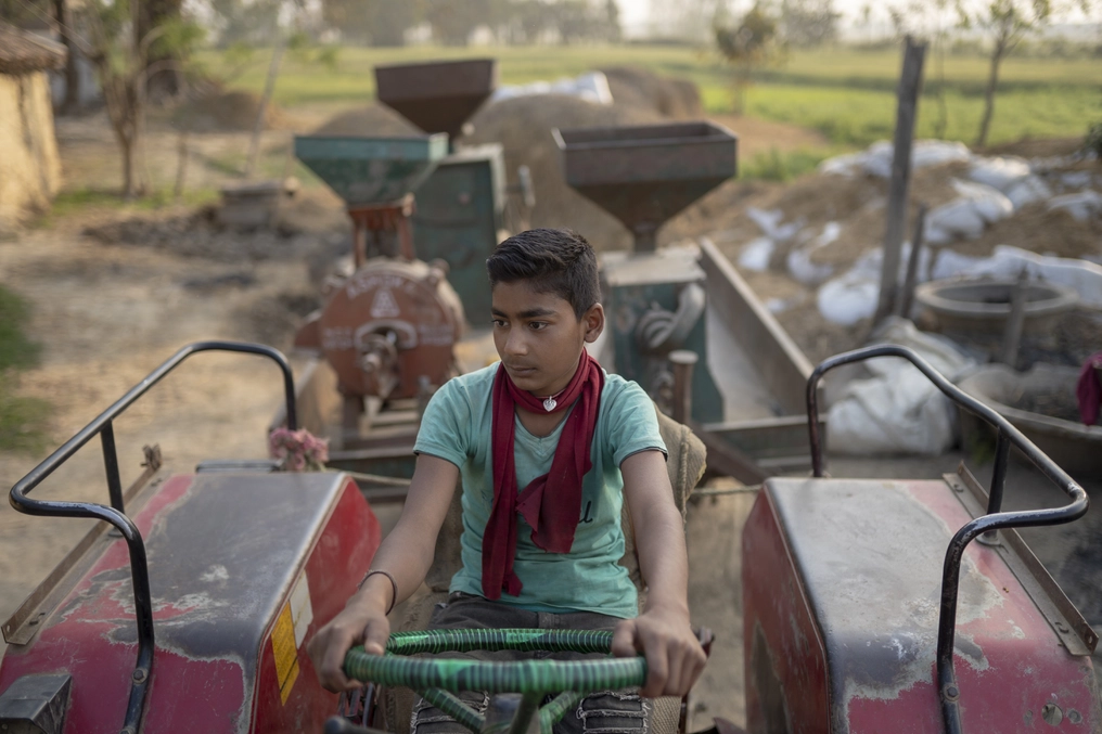 One of Lorik’s sons sits atop the mobile mill. (AtlasNetwork.org Photo / Bernat Parera)