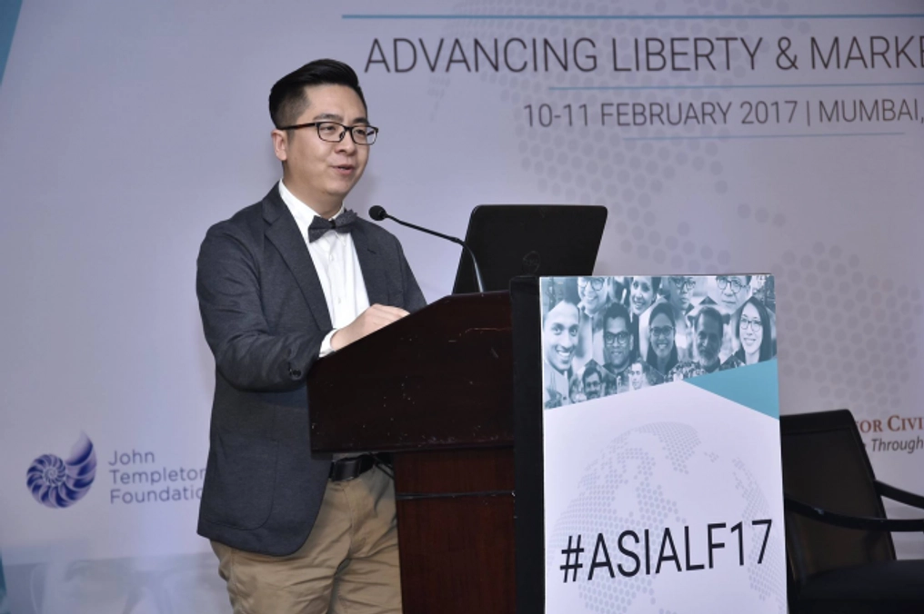 A man delivers a speech at a podium at the Asia Liberty Forum.