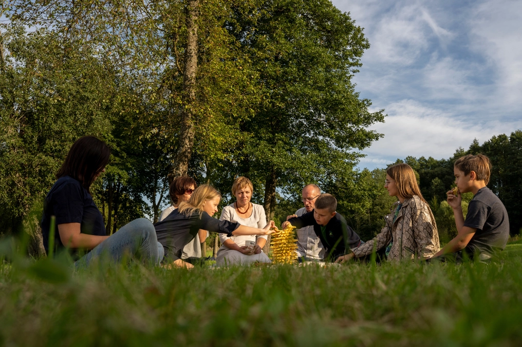 LFMI staff and family enjoy the finished šakotis as the sun sets in Zūbiškės (AtlasNetwork.org Photo/Bernat Parera).