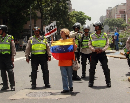 An elderly demonstrator defies riot police during a rally against Venezuela’s President Nicolás Maduro. Venezuelans protest over food and medicine shortages in Caracas, Venezuela (April 20, 2017). Editorial Credit: Edgloris Marys / Shutterstock.com.